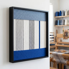 Side profile of the framed wool wall art in a workshop setting, showcasing the depth and dimensional layered winding technique.