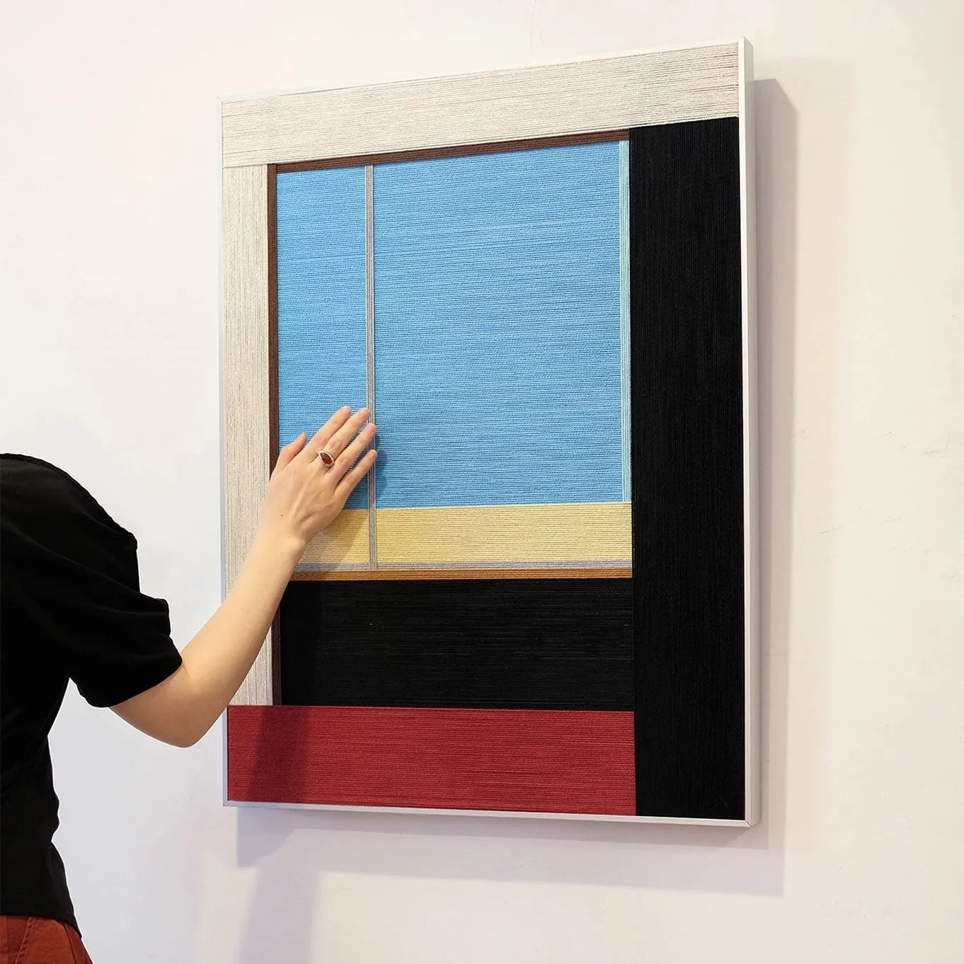 Hand-held view of After the Beach Walk yarn wall art showing its compact square form and precise coastal-stripe composition