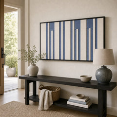 Striking Blue Cadence framed wall art styled in a bright entryway, hanging above a sleek black console table with vases.