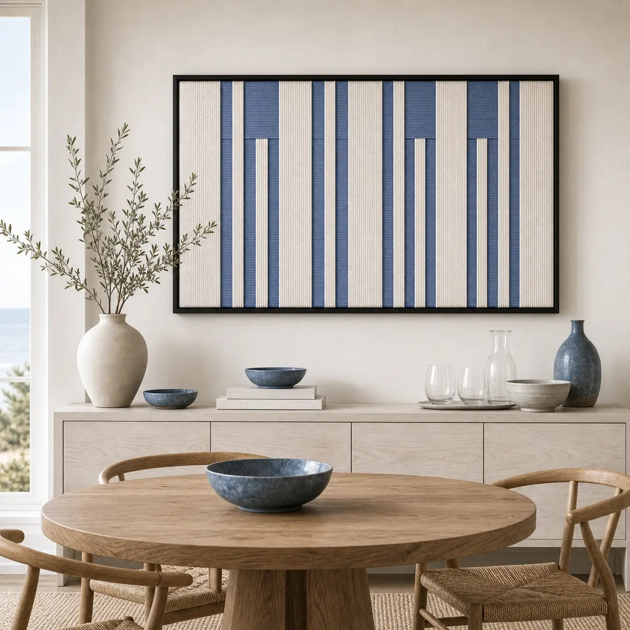 Blue and white geometric hand-woven wool tapestry beautifully staged in a bright dining room over a wooden sideboard.
