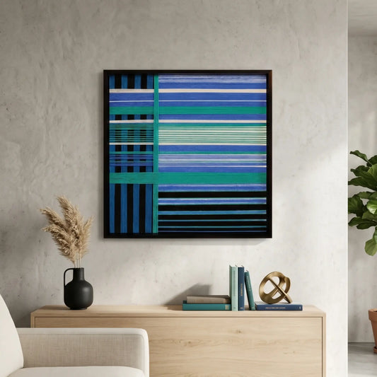 Square hand-woven wool wall art in a black frame featuring a complex geometric grid of cobalt blue, teal, and navy horizontal and vertical stripes, styled above a light wood sideboard.