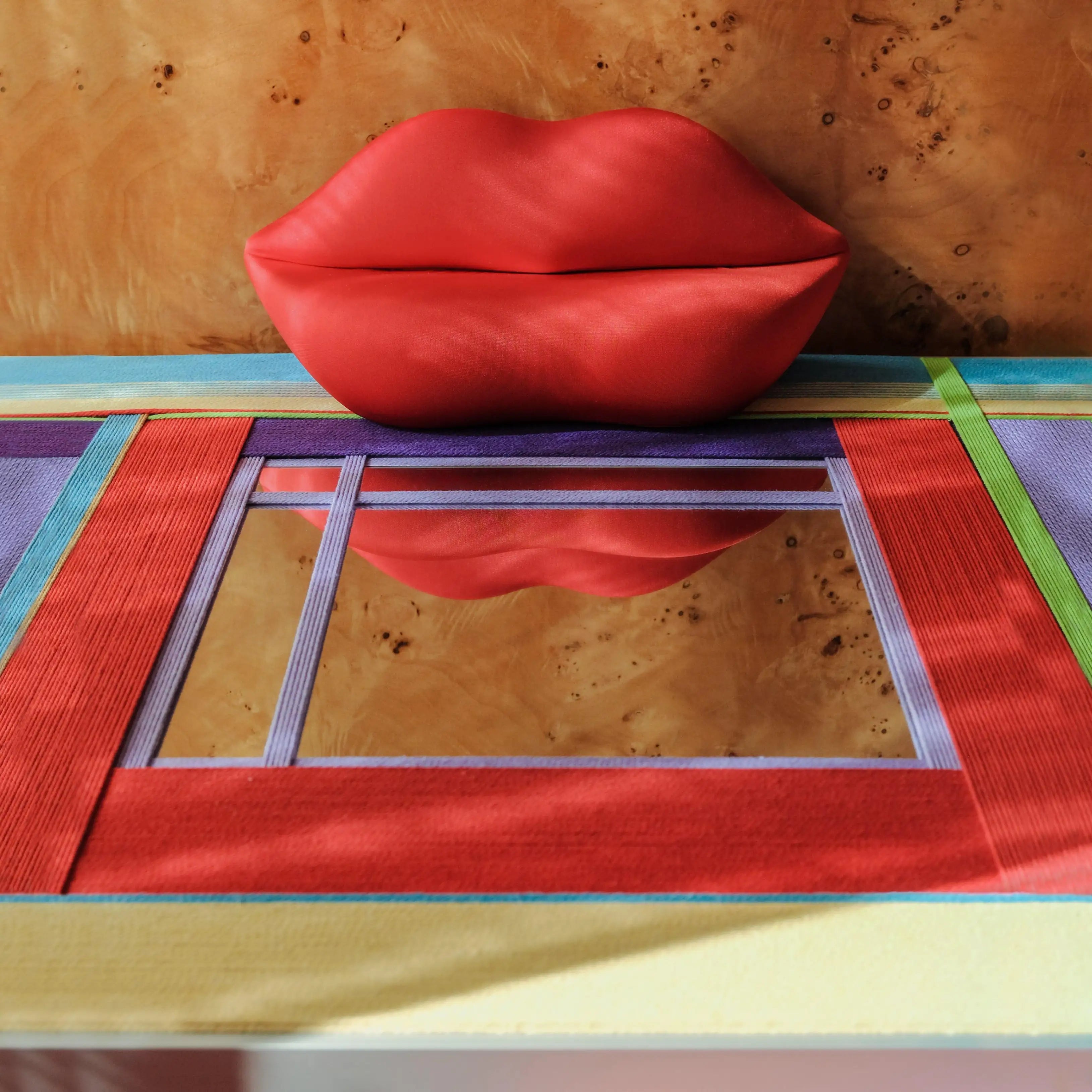 Close‑up of Bohemian Reverie yarn mirror art revealing tight looped wool texture and crisp transitions between pastel and red stripes.