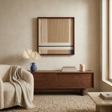 Modern soft cotton cord wall hanging styled above a mid-century modern wooden credenza with neutral decor and a blue ceramic vase.