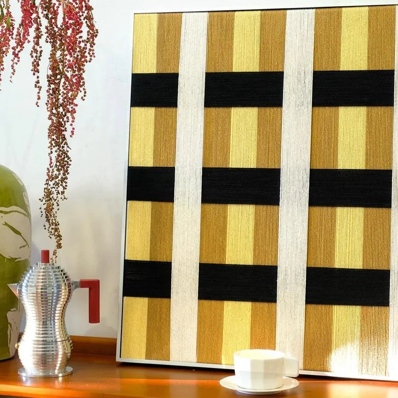 Angled detail of Downton Manor yarn wall art highlighting tight wool weave and crisp transitions between black and gold grid panels.