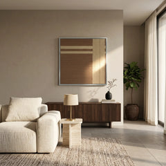 Handmade wool wall art in a silver frame placed above a wooden console table next to a large indoor plant.