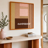 Folded Dialogue pink beige and espresso textile wall art displayed above a stone and wood console in a warm minimalist entryway.