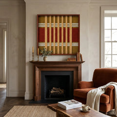 Beautiful framed Gilded Coronation textile wall art styled elegantly above a dark wood fireplace mantel next to a cozy rust-colored armchair.