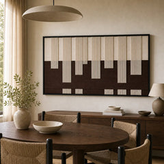 The Ivory Loom framed wall art provides a stunning focal point over a round wooden dining table and chairs.