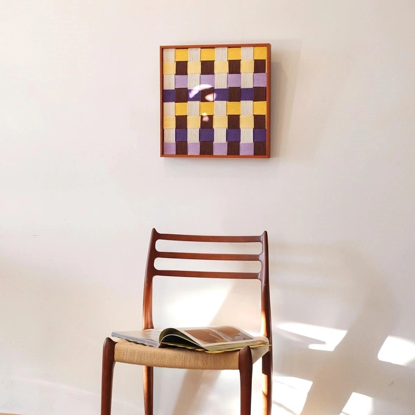 Mrs Dalloway wall art placed on a chair with sunlit shadow patterns.