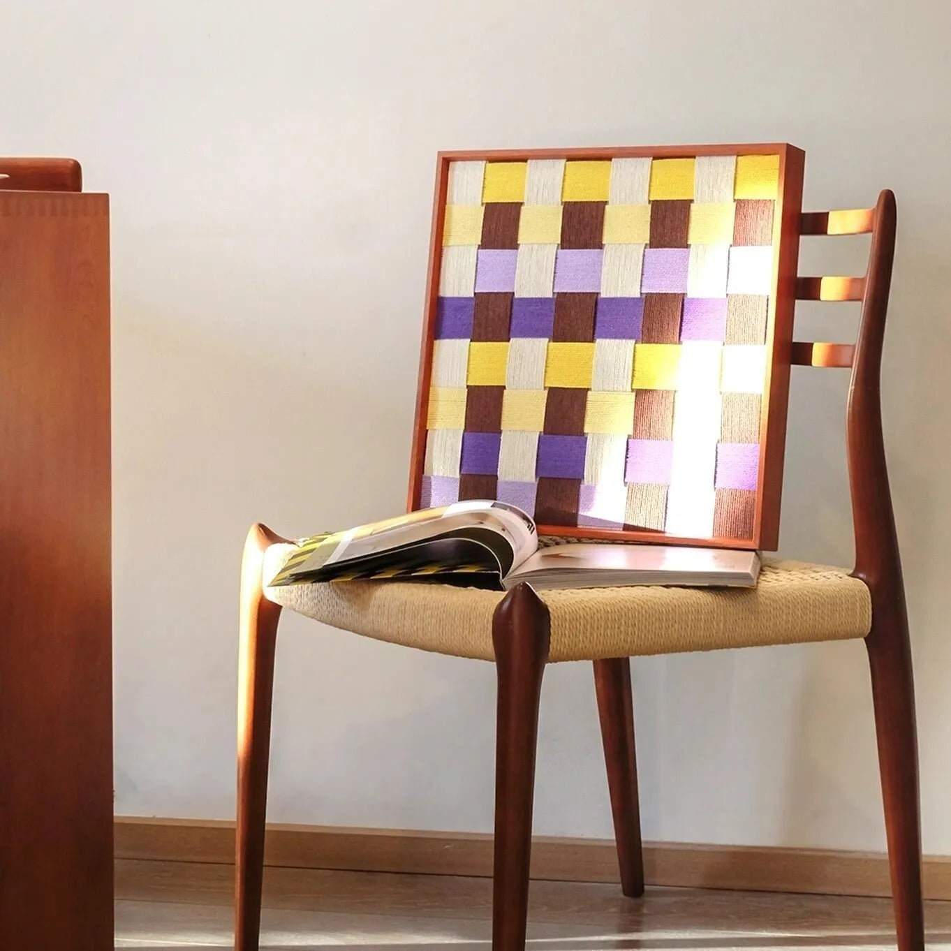 Mrs Dalloway wall art leaning on a wooden chair against a white wall.
