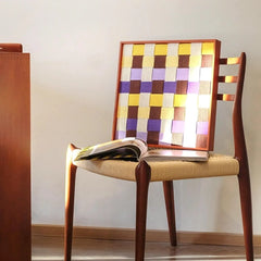 Mrs Dalloway wall art leaning on a wooden chair against a white wall.