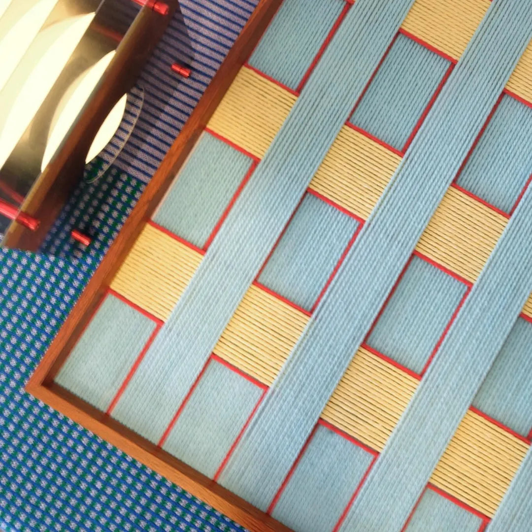 Close-up of the wooden frame corner joint, emphasizing craftsmanship and the way it complements the yarn weave