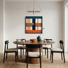 Modern orange and navy fiber wall art styled in a contemporary dining room with a round wooden table and minimalist chairs.