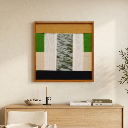 Square hand-woven wool wall art in a cherry wood frame featuring an abstract landscape with green, mustard yellow, and white panels and a central textured grey section, styled above a light oak sideboard.