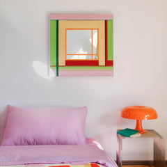A cozy bedroom setting featuring the textured fiber wall mirror above a bed with pink linens, creating a romantic and modern atmosphere.