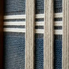 Detailed macro close-up of the Polar Meridian hand-woven textile art highlighting the textured navy blue base and raised white vertical yarn strips.