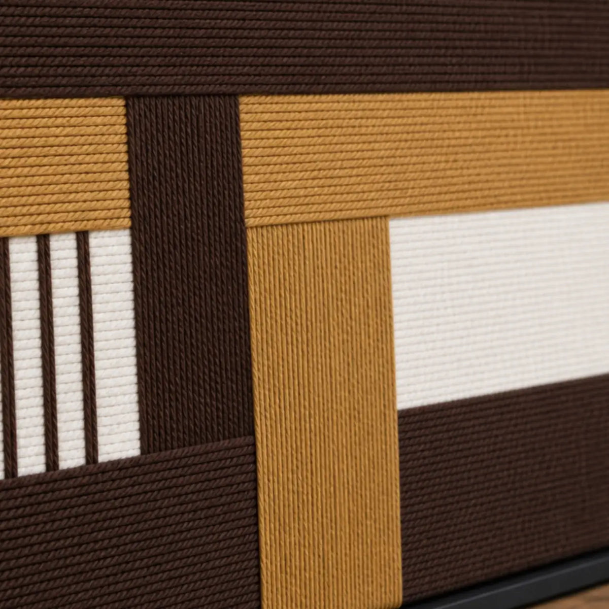 Macro close-up of Cocoa Loom RE029 textile art highlighting thick brown, beige, and white intersecting soft cotton cord textures.