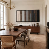 Framed Umber Columns woven wall hanging with vertical brown, grey, black, and cream stripes in a refined room.