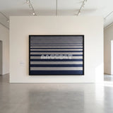 View of Linear Gradient framed textile wall art, featuring navy blue and light grey horizontal cotton cord stripes graduating from fine to broad bands.
