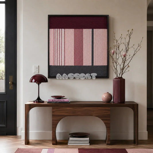 Rosy Pulse dusty rose burgundy and charcoal textile wall art displayed above a sculptural walnut console in an elegant modern entryway.