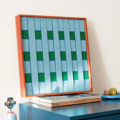 Seine Riverbank yarn wall art styled on a laptop keyboard with matching yarn balls, showcasing precise stripe alignment and compact square design