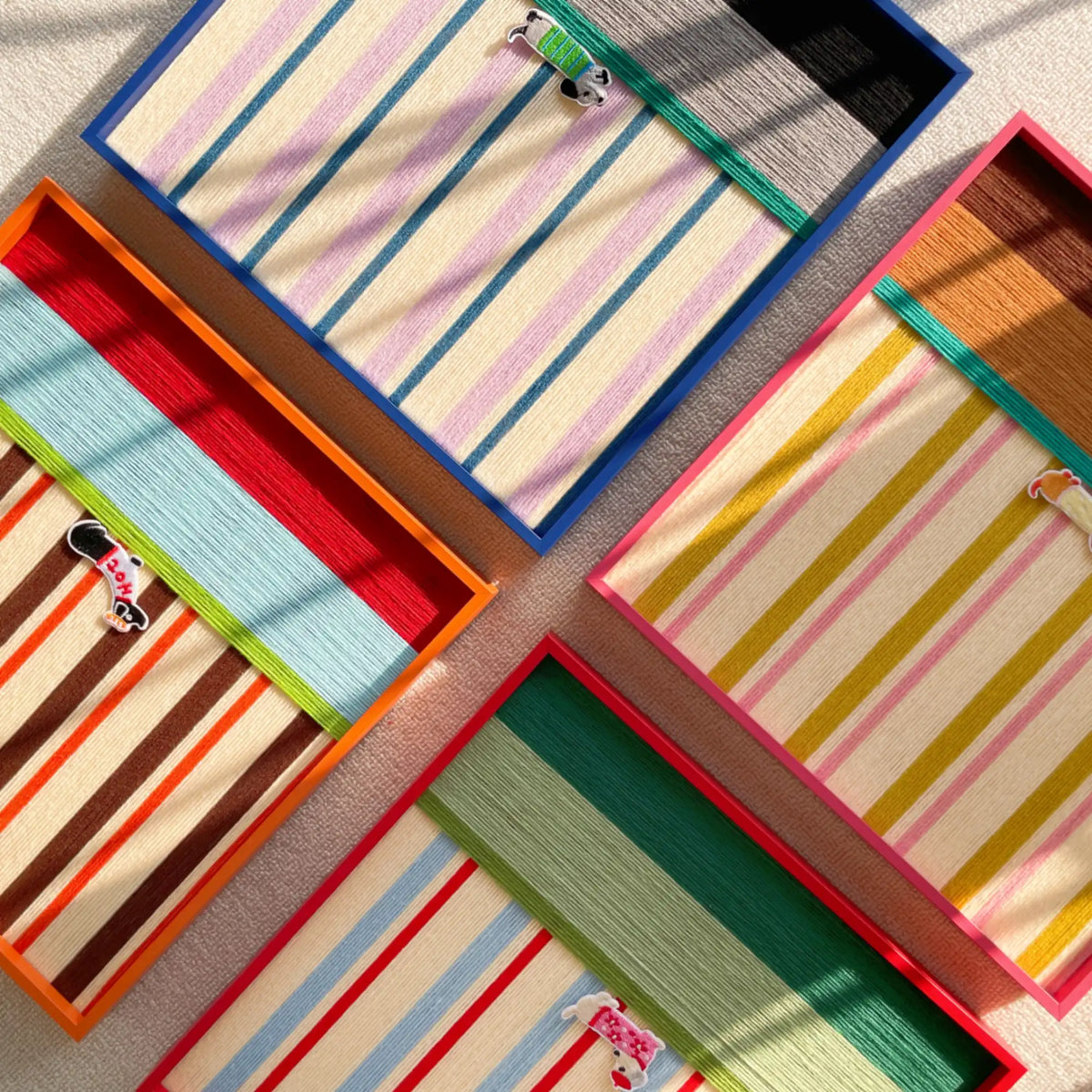 A creative layout showing several soft cotton cord wall art pieces overlapping to highlight different colorful striped patterns and textile textures.