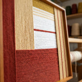 Angled close-up of Sun-Baked Terra SQ086 showing terracotta, ochre, and cream yarn in a textured geometric layout.