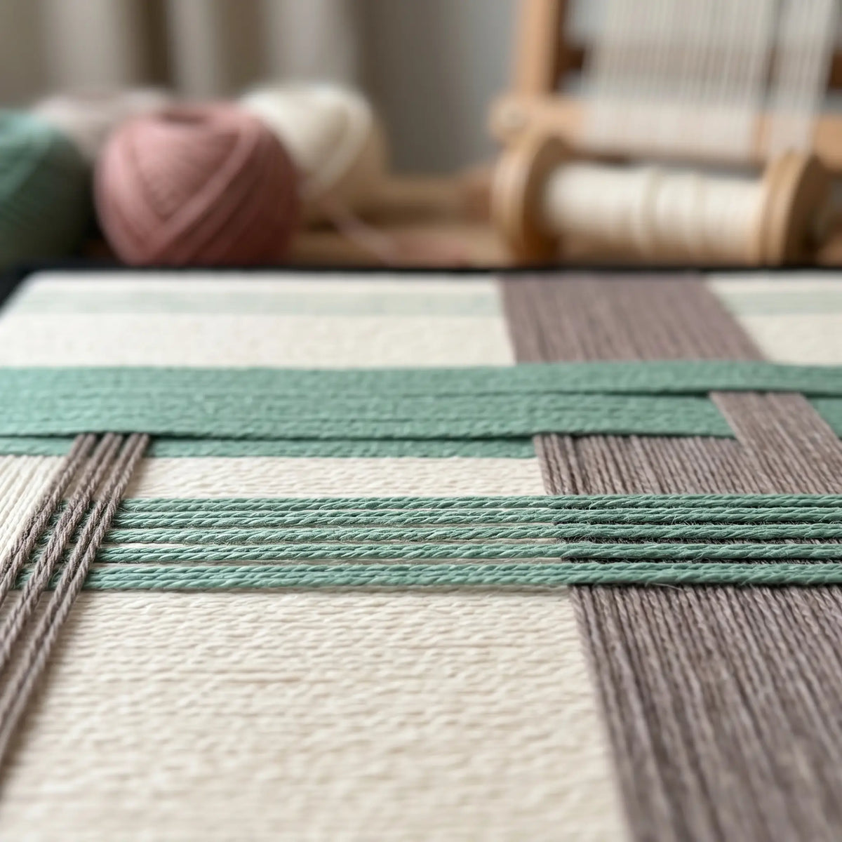 Angled workshop view of Muted Spring SQ115 highlighting dimensional sage green and gray yarn craftsmanship.