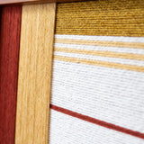 Extreme close-up of Crimson Daybreak SQ127 highlighting textured crimson, mustard yellow, and white yarn details.