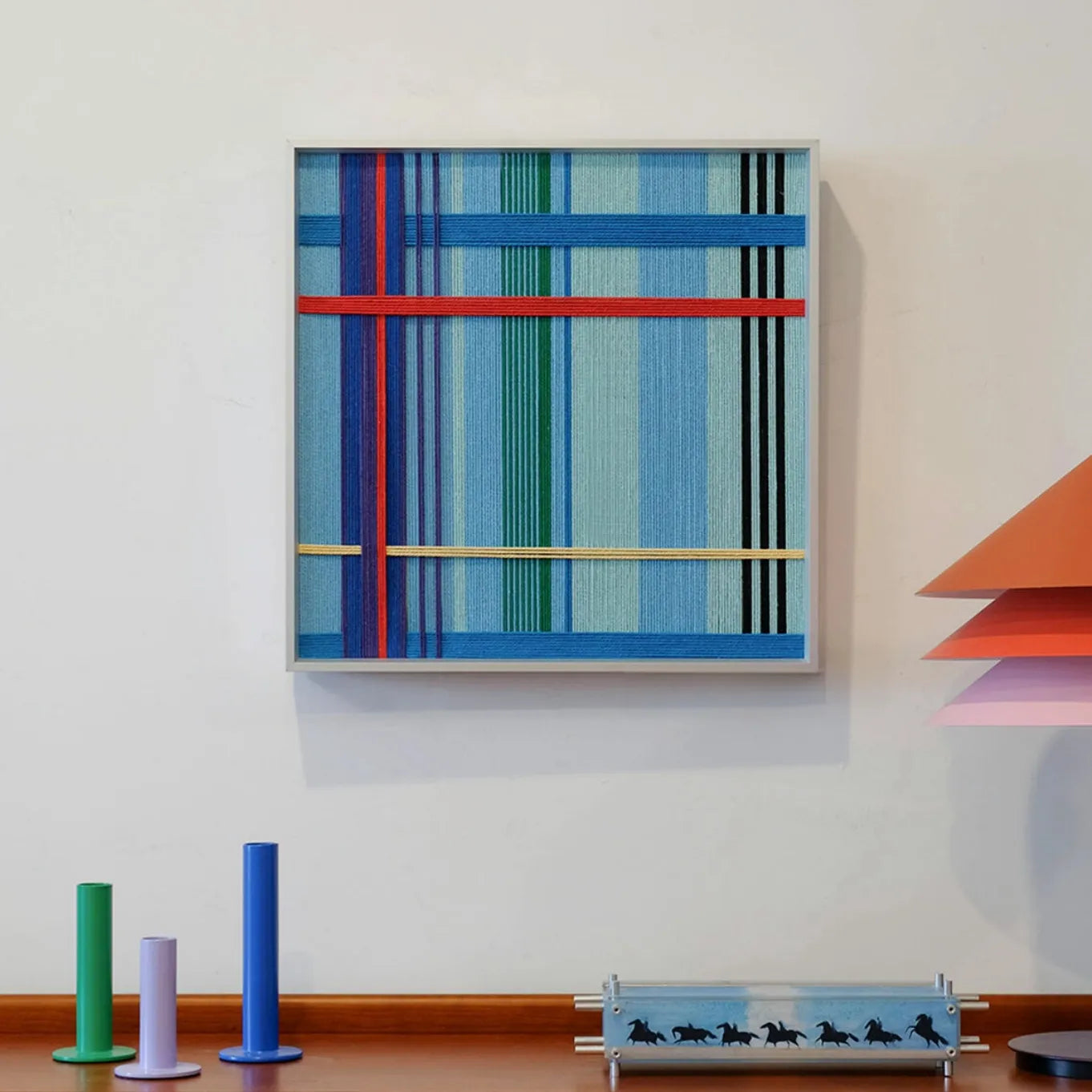 Summer Story yarn wall art placed on a tabletop along with matching yarn balls, highlighting texture and color coordination