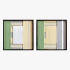 Frontal studio shot of the Sun-Baked textile art pair, showcasing two matching square hand-woven wall art pieces with yellow, white, and green geometric designs in black frames.