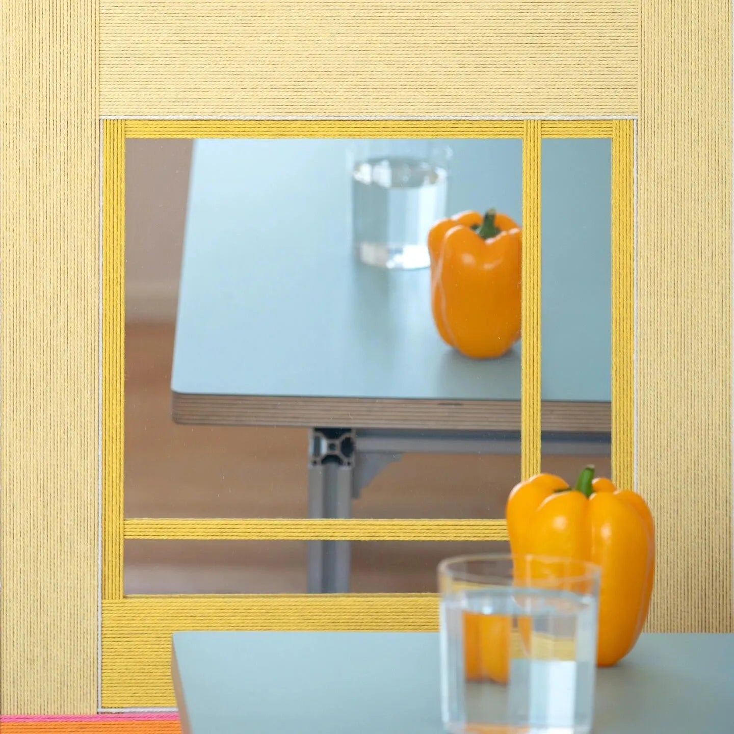 Sun‑Drenched Days yarn wall art resting on a tabletop next to a pastel vase and fruit bowl, emphasizing its versatile display options.