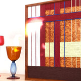 Artistic close-up of the woven wool tapestry with a light flare, highlighting the intricate texture and vibrant red and orange color palette.