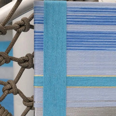 Macro shot of That Summer, the Blue Sea hand-woven wool surface, emphasizing tactile looped yarn texture and vibrant blue hues