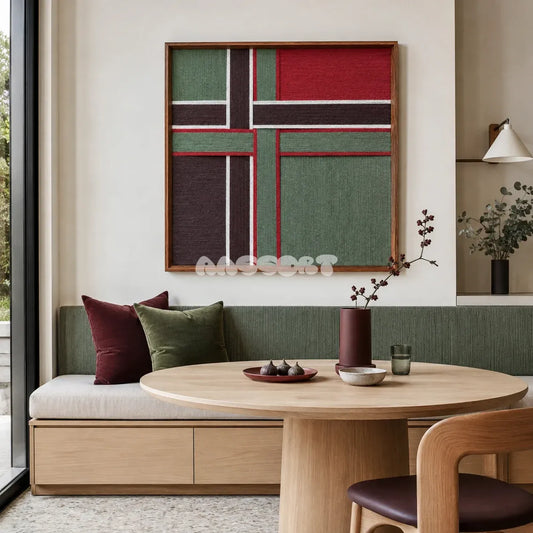 The Gift Ribbon red, moss green, dark brown, and white yarn wall art displayed above a banquette in a modern dining nook.