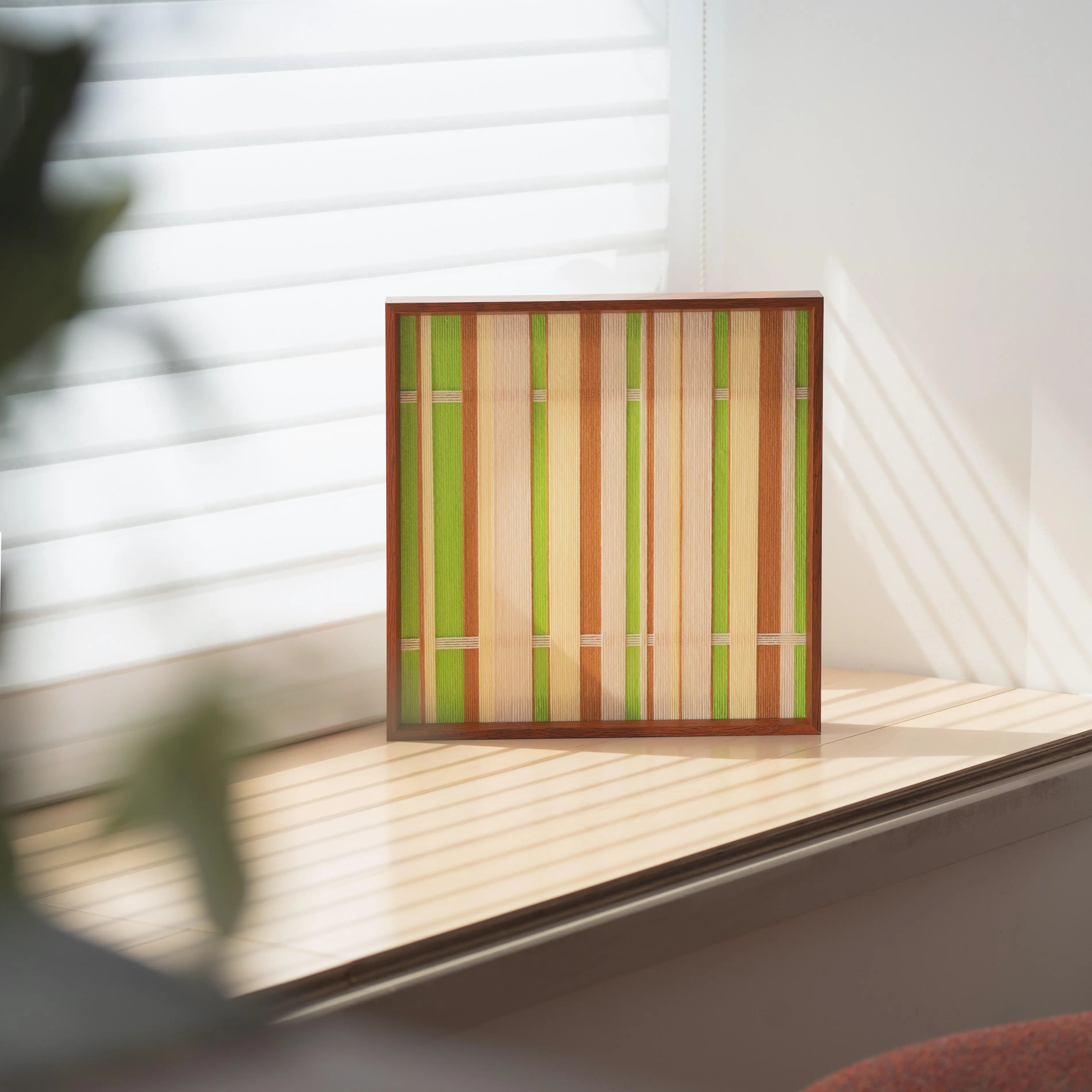 Tree Ah Tree yarn woven wall art featured in a lush garden environment