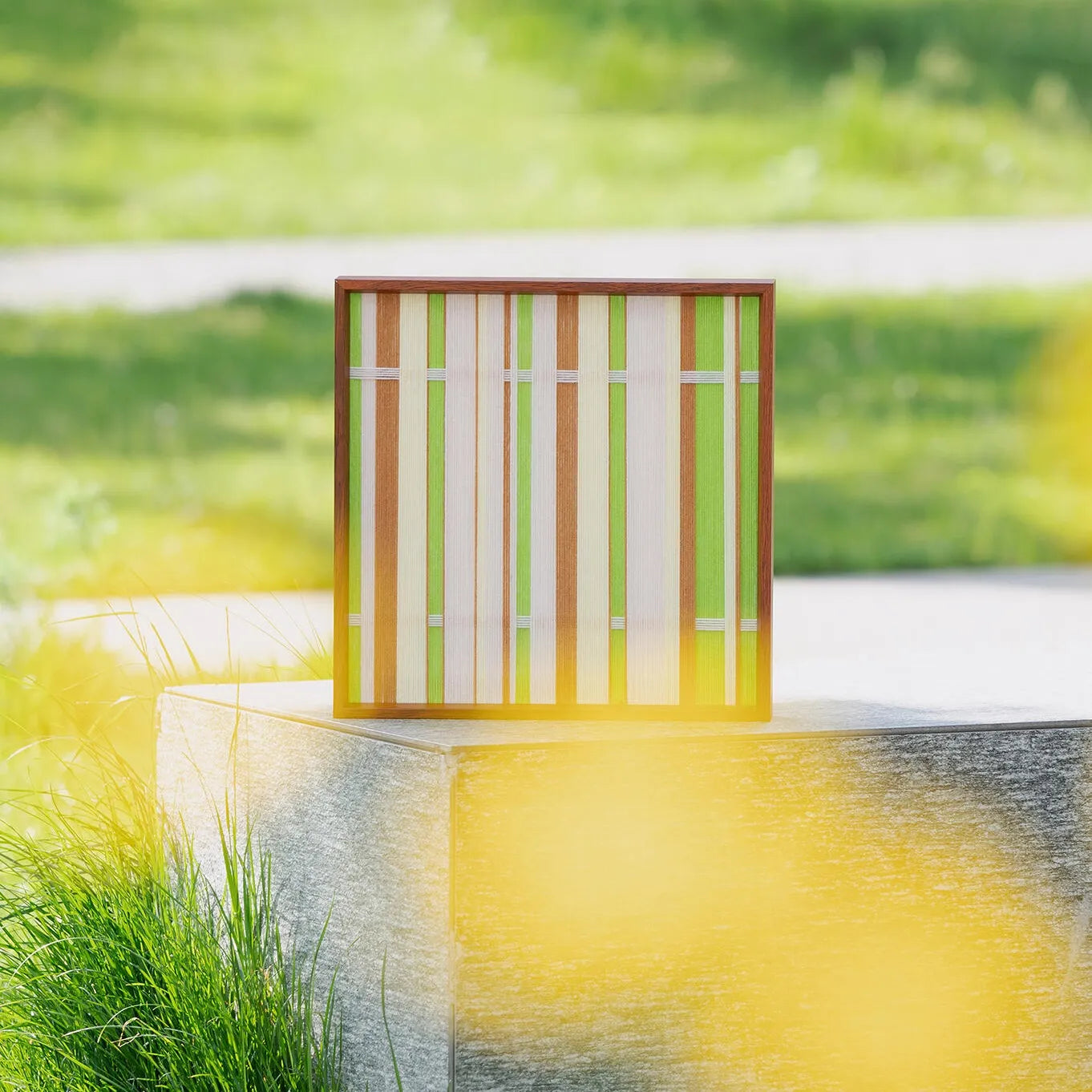 Tree Ah Tree wall art displayed outdoors with blurred yellow flowers in foreground