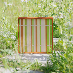 Tree Ah Tree wall art displayed outdoors with blurred yellow flowers in foreground