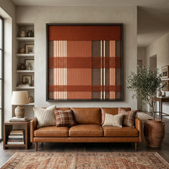 Beautiful framed hand-woven textile wall art styled elegantly above a classic tan leather sofa in a warm, inviting living room with a patterned area rug.