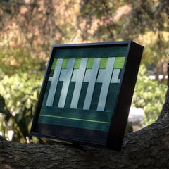 Angled view of Velvet Vine yarn wall art highlighting dense stitch work of premium wool and crisp transitions between green and white stripes