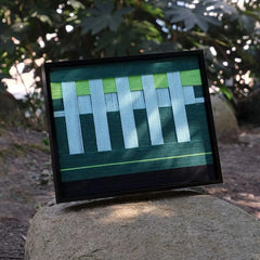 Velvet Vine yarn art displayed on a boulder, highlighting its sturdy black frame and alternating green-white stripe design
