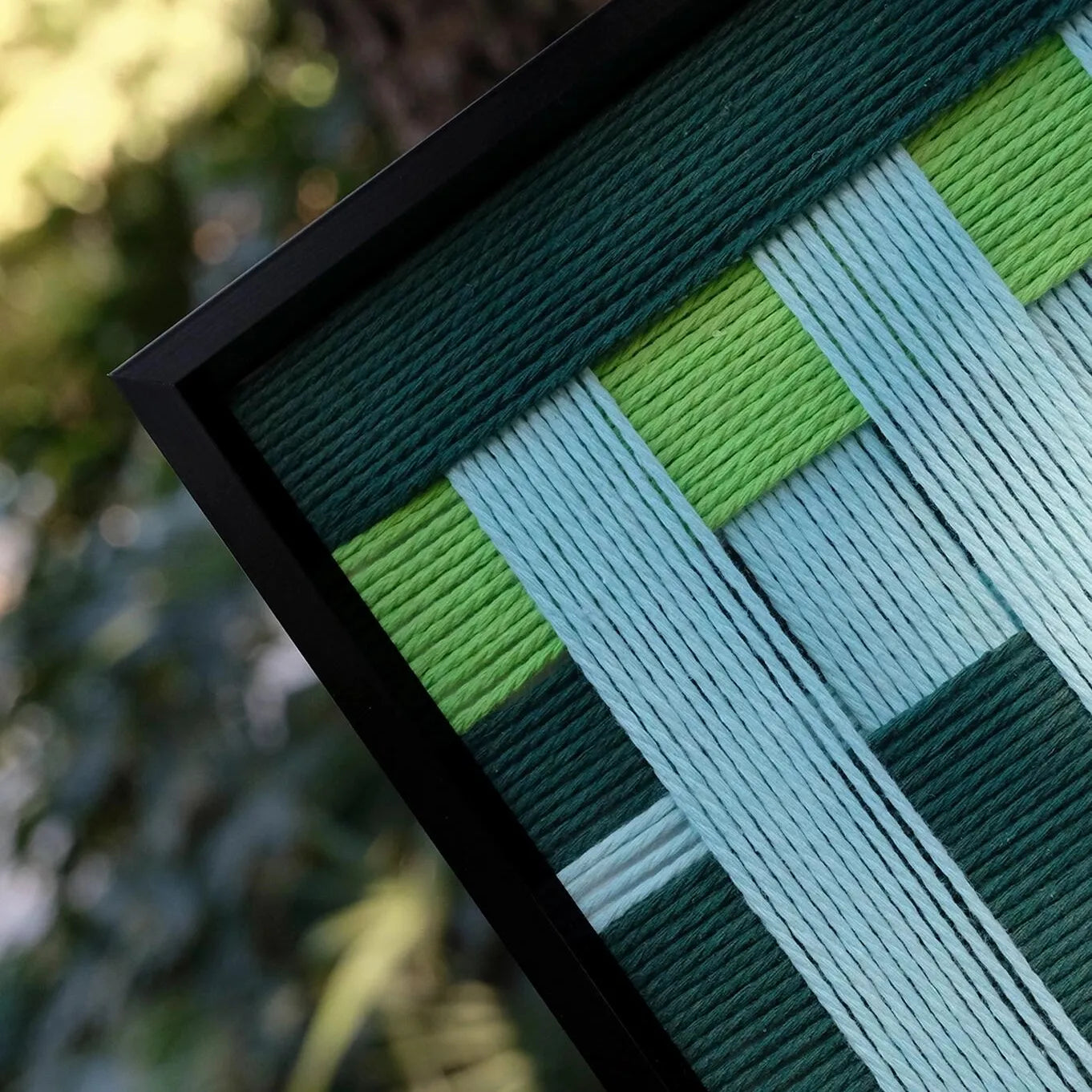 Front view of Velvet Vine hand-woven yarn wall art on plain white background, displaying exact square proportions and clean green-stripe pattern