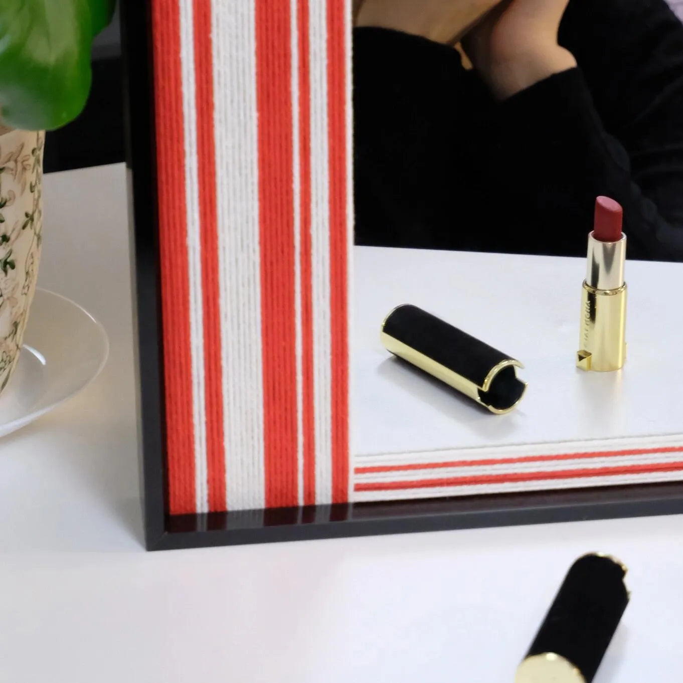 Macro view of Wave Tide yarn art showing looped wool texture of the red and white stripe panels against the black frame.