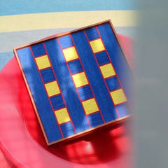 Window Peek at Moon wall art styled against a red surface to emphasize its alternating blue stripe pattern and bold color contrast
