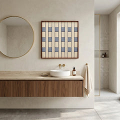Framed checkered wool art hanging in a minimalist spa-like bathroom with a round mirror and wood accents.