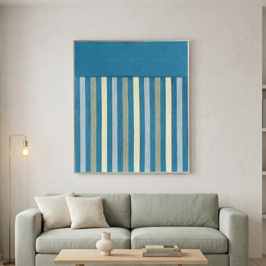 Blue Night blue and gray striped fiber wall art displayed above a light gray sofa in a minimalist living room