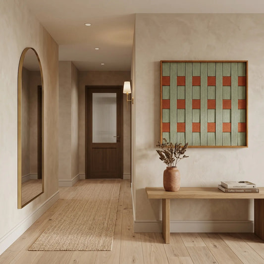 Square woven wool tapestry styled in a minimalist entryway above a simple wooden console table.