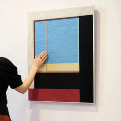 Hand-held view of After the Beach Walk yarn wall art showing its compact square form and precise coastal-stripe composition
