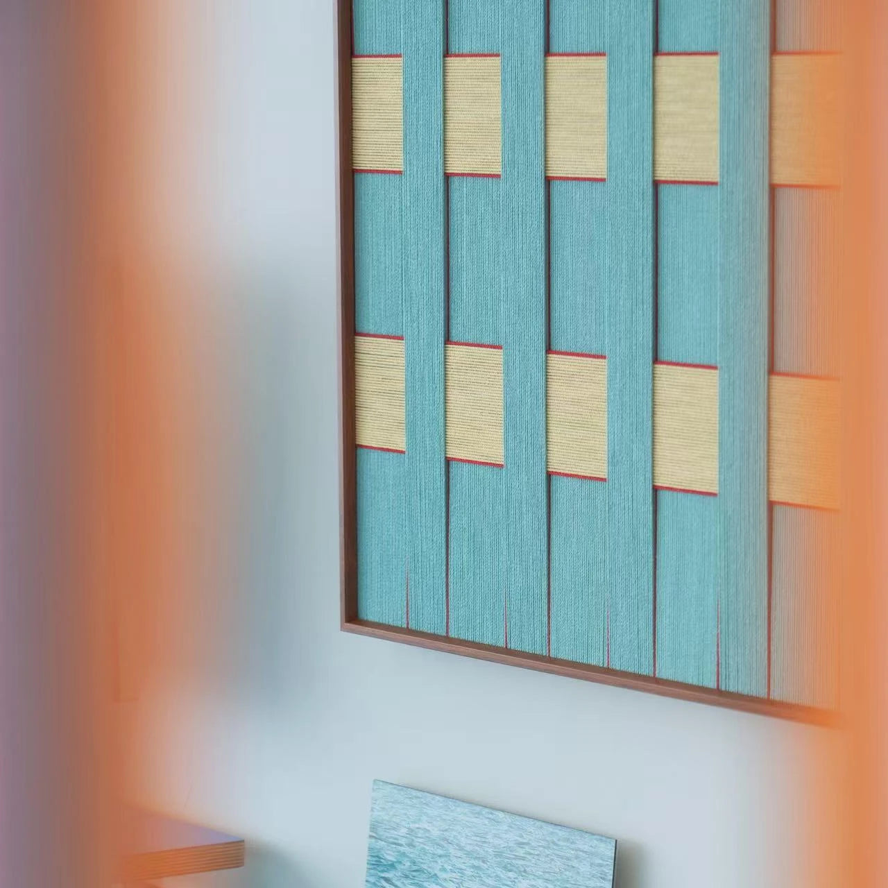 Close-up side view of the Afternoon Window hand-woven wool tapestry highlighting the thick vertical teal fibers and wooden frame depth.