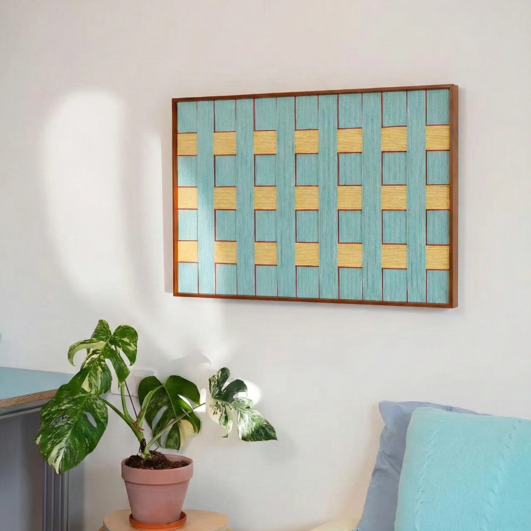 Handmade wool wall art piece in a study area styled with a monstera plant, reflecting soft natural afternoon light.